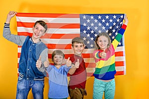 Happy and joyful children flying the American flag, the concept of protection and patronage of the USA