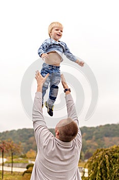 Happy joyful father having fun throws up in the air child. Family, travel, vacation, father`s day concept.