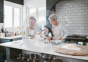 .Happy, joyful and loving mother and grandmother cooking, baking and preparing food with their daughter and grandchild