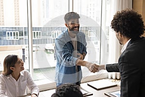 Happy joyful project leader selling startup, giving handshake to investor