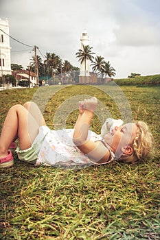 Happy joyful smiling child girl having fun lying on grass concept happiness joy childhood lifestyle