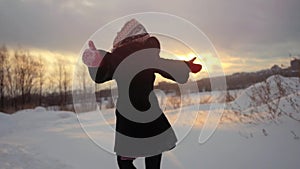 Happy joyful woman having fun outdoors throwing snow in winter snowy nature in slow motion during sunset. 1920x1080