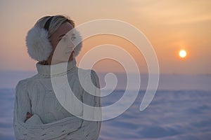 Happy joyful woman having fun outdoors in winter, standing on the mountains with raised up hands on the mountain covered