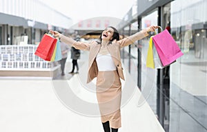 Happy joyful woman with purchases in mall closeup