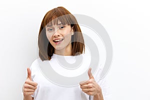 a happy, joyful woman with red hair and a beautiful hairstyle looks at the camera smiling and gives a thumbs-up gesture