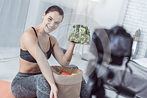 Happy joyful woman showing a pack with salad