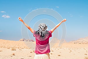 Happy joyful woman tourist stand with hands up on wadi rum desert on hike on holiday vacation in Wadi rum. Popular Wadi Rum desert