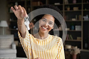 Happy joyful young African woman showing keys at camera