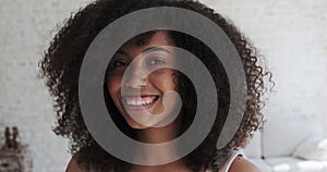 Happy joyful young black lady with curly hair delighted at good news or birthday celebration,