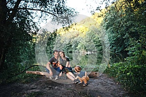 Happy joyful young family father, mother and little son outdoors, hugging together in summer park