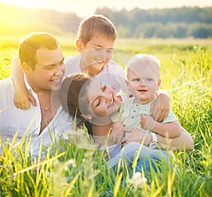 Happy joyful young family with little sons outdoors