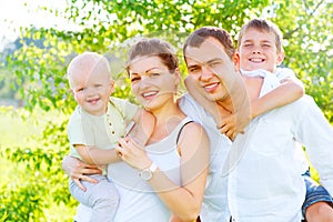 Happy joyful young family in summer park