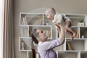 Happy joyful young mom playing with sweet baby