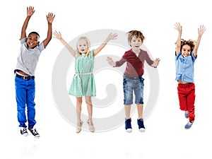 Happy, jumping and portrait of children in studio for diversity, friends and playing. Happiness, youth and smile with