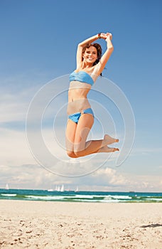 Happy jumping woman on the beach