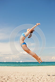 Happy jumping woman on the beach