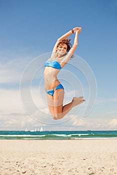Happy jumping woman on the beach