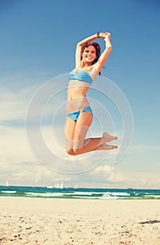 Happy jumping woman on the beach