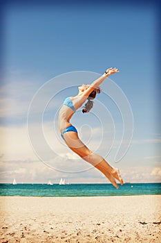 Happy jumping woman on the beach