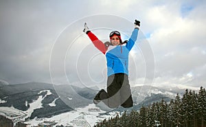 Happy jumping woman in winter in ski resort