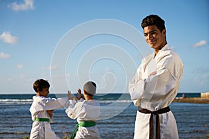 Happy Karate Sport Instructor Watching Young Boys Fighting