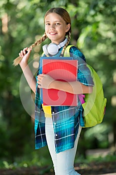 Happy kid back to school holding long hair plait natural landscape, hairstyle