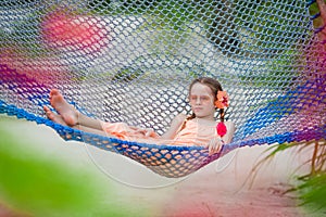 Happy kid in blue hammock outdoor at the beach