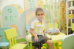 Happy kid boy celebrating birthday party in cafe.