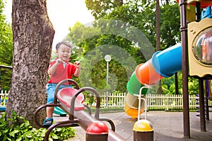 Happy kid, boy having fun on playground in park