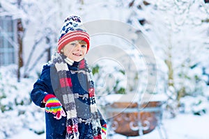 Happy kid boy having fun with snow in winter