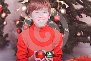 Happy kid boy holding christmas decorations