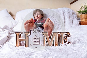 Happy Kid boy plays games with controller and lying on the bed at home and relax. Stay at home safety quarantine