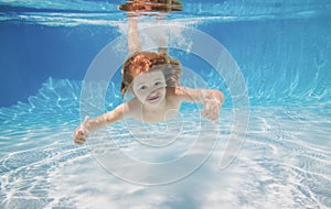 Happy kid boy swim and dive underwater, kid with fun in pool. Active healthy lifestyle, watersport under water, kids