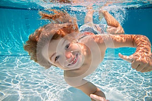 Happy kid boy swim and dive underwater, kid with fun in pool under water. Active healthy lifestyle, water sport activity