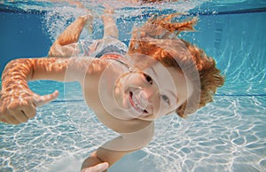 Happy kid boy swim and dive underwater, kid with fun in pool under water. Active healthy lifestyle, water sport activity