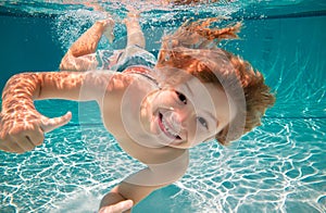 Happy kid boy swim and dive underwater, kid with fun in pool under water. Active healthy lifestyle, water sport activity