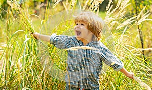 Happy kid. Cute child on nature grass background. Happy scream, delight. Childrens emotions on a beautiful face