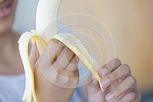 Happy kid enjoy eating fresh fruit. Healthy little girl eating banana photo