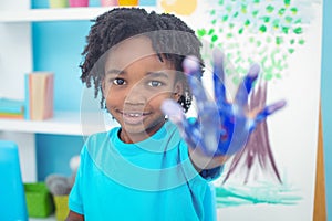 Happy kid enjoying painting with his hands