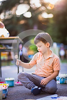 Happy kid enjoying painting with water colours