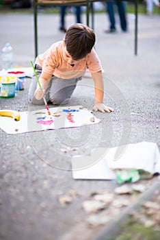 Happy kid enjoying painting with water colours