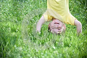 Happy kid enjoying sunny late summer and autumn day in nature on green grass.