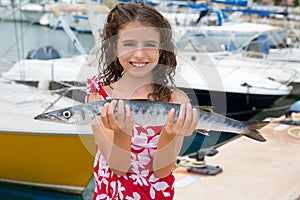 Happy kid fisherwoman with barracuda fish catch