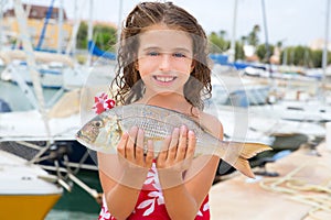Happy kid fisherwoman with dentex fish catch