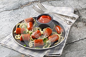 Happy kid food for Halloween party spaghetti with sausages and ketchup close-up in a plate. Horizontal