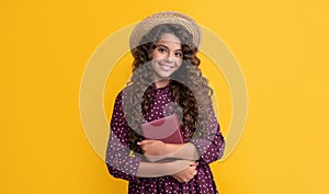 happy kid with frizz hair hold book on yellow background