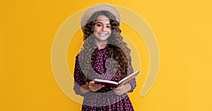 happy kid with frizz hair read book on yellow background