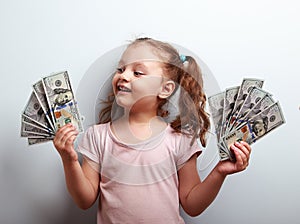 Happy kid girl holding cash dollars and looking with smile