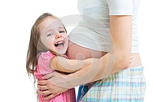 Happy kid girl hugging pregnant mother's belly