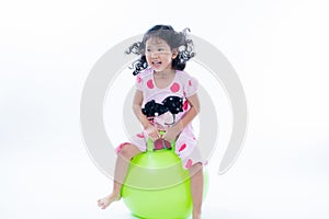 Happy kid girl jumping on bouncing ball